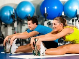 Couple Exercising Stretching at the Gym