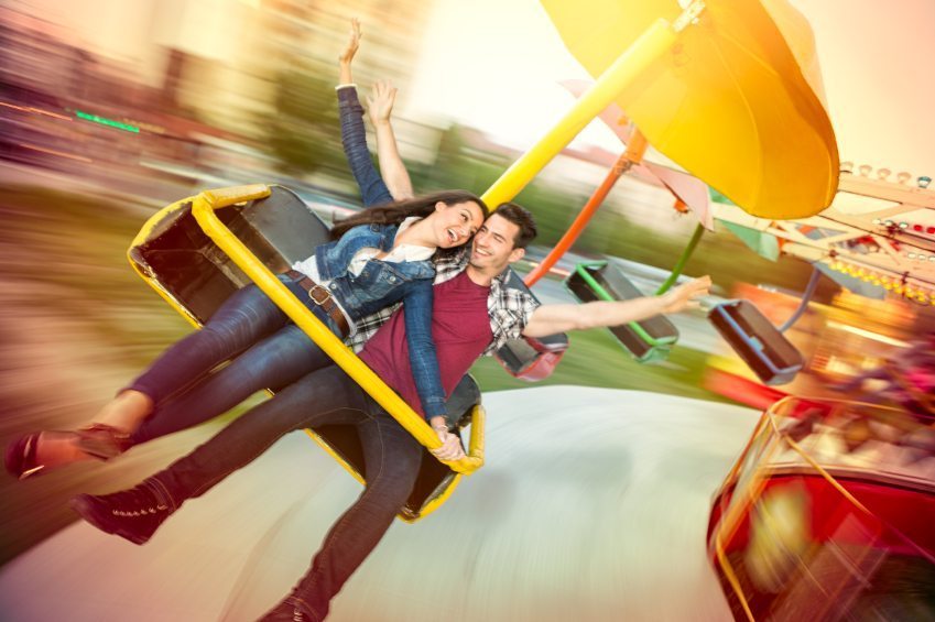Young happy couple having fun at amusement park