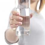 Happy woman hand holding a fresh glass of water