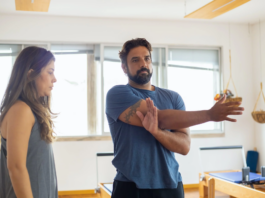 A woman looking over a man who is stretching